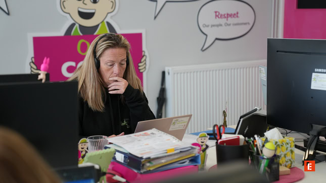 focused woman working at a cluttered desk