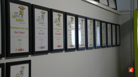 framed awards wall in office corridor