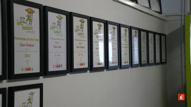 framed awards wall in office corridor