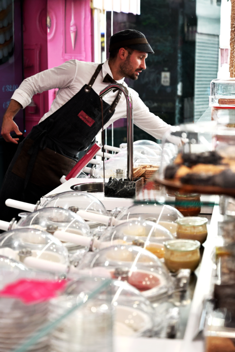 gelataio al bancone in gelateria artigianale