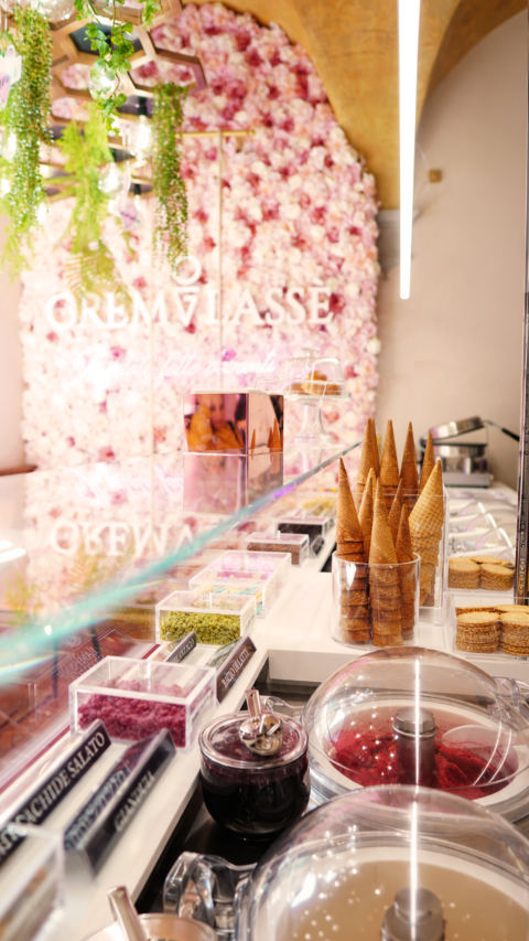 gelateria artigianale: coni, guarnizioni e parete fiorita