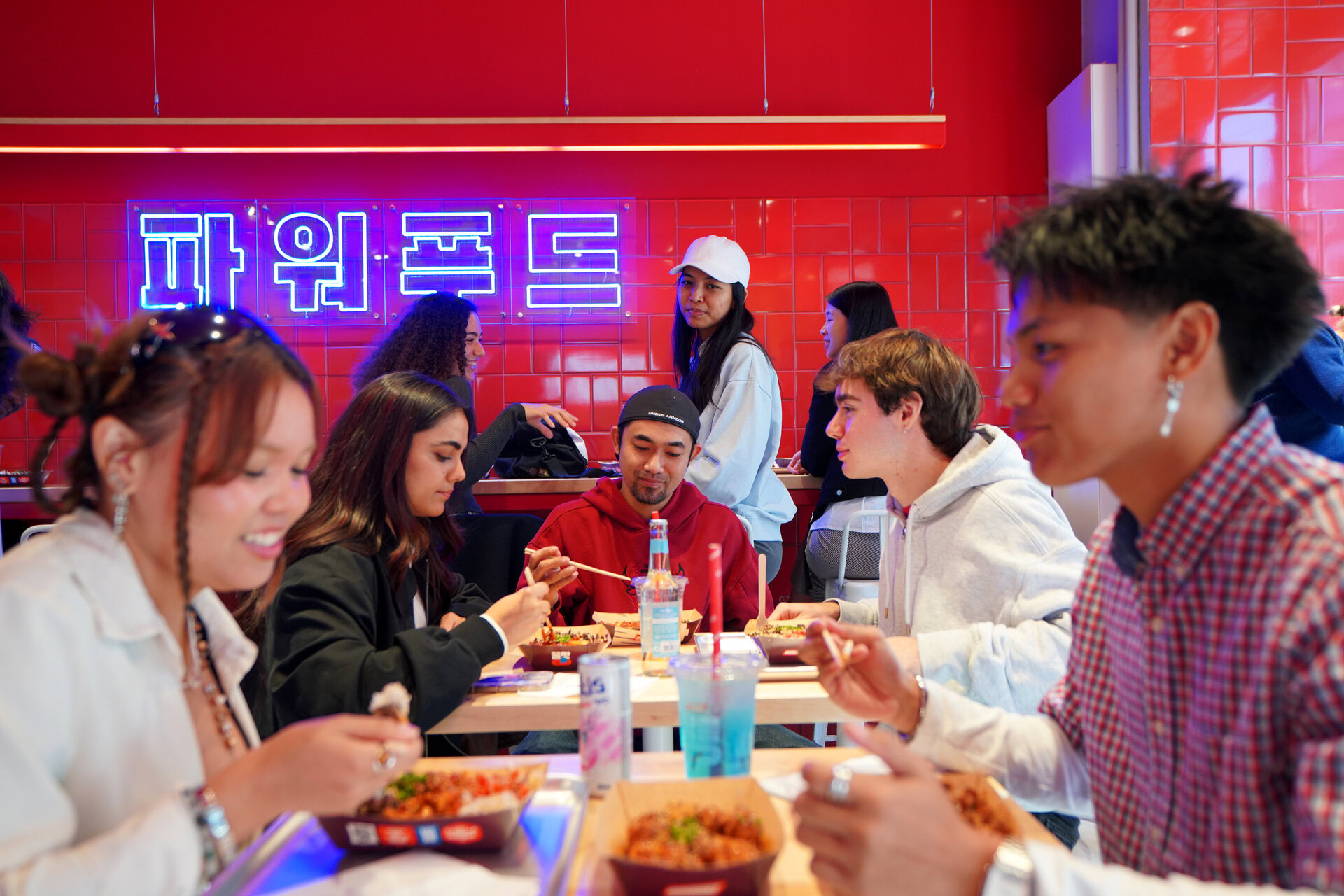 junge leute beim gruppenessen im neon restaurant