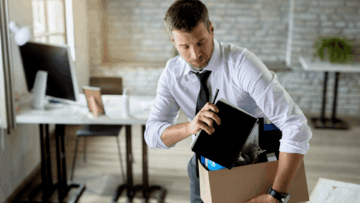 hombre empacando pertenencias en oficina