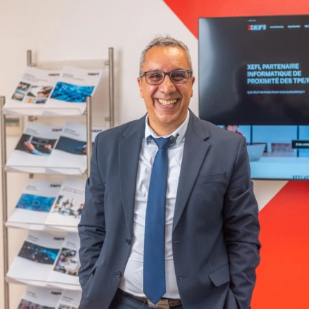 homme souriant en costume dans bureau informatique moderne