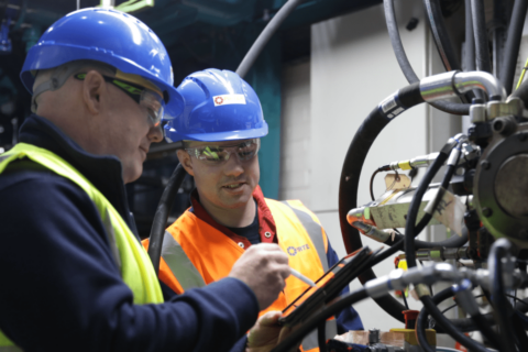 industrial workers inspecting hydraulic hoses