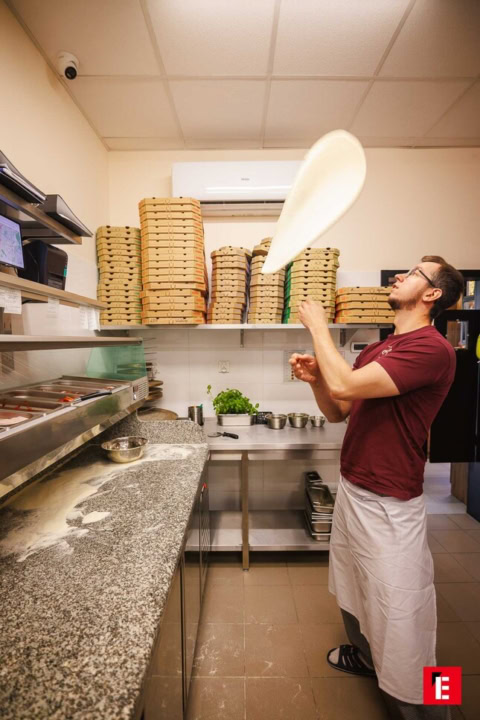 sztuka podrzucania ciasta do pizzy w profesjonalnej kuchni