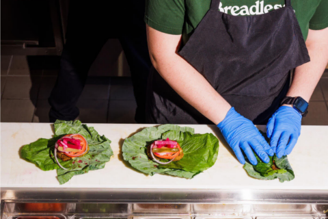 fresh leaf wraps assembled by gloved hands