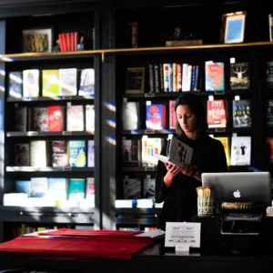 lettore al banco della libreria illuminato dal sole