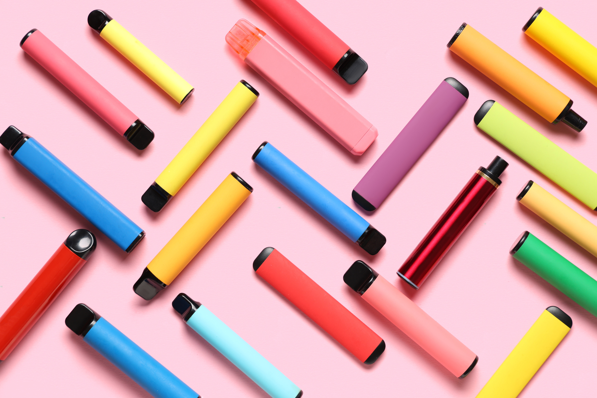 stylos colorés pastel sur fond rose