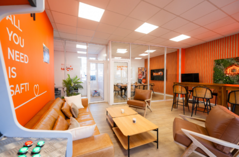 lounge orange en cuir et salle de réunion vitrée
