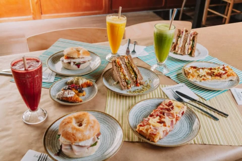 brunch variado con sándwiches, croissants y jugos frescos