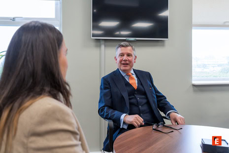 executive in orange tie leading office meeting