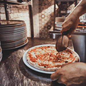Corte de una pizza napolitana con cortapizzas.
