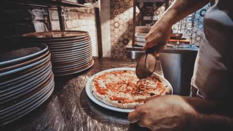 Corte de una pizza napolitana con cortapizzas.