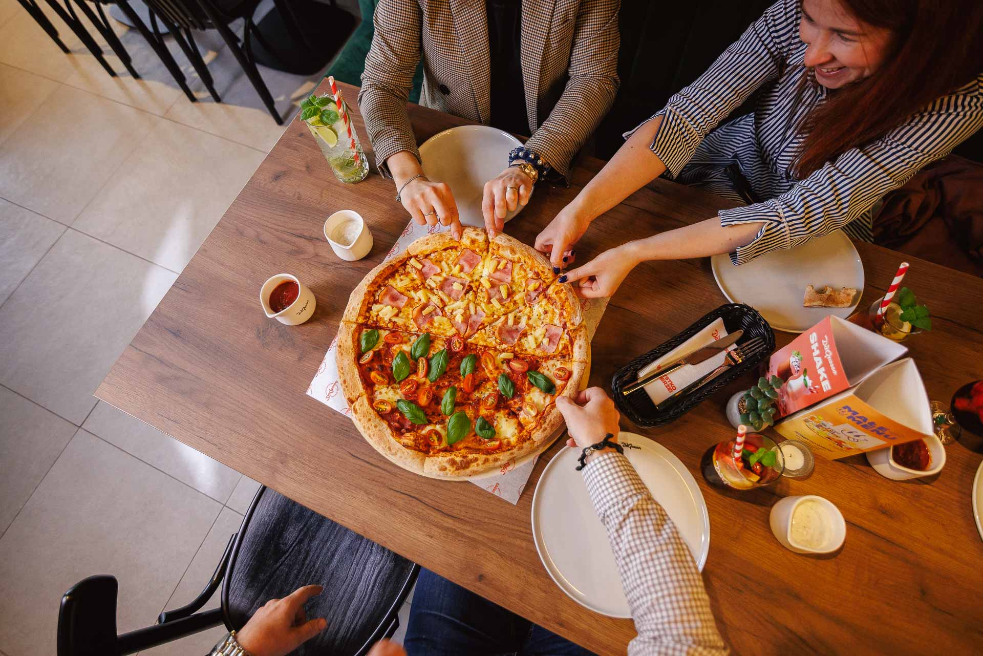przyjaciele dzielą pizzę w przytulnej kawiarni
