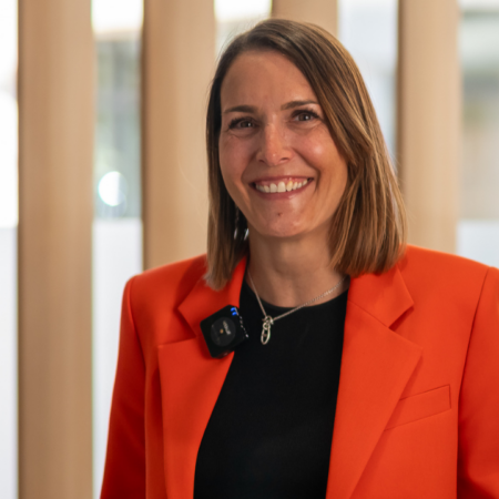 portrait professionnel dune femme souriante en veste orange
