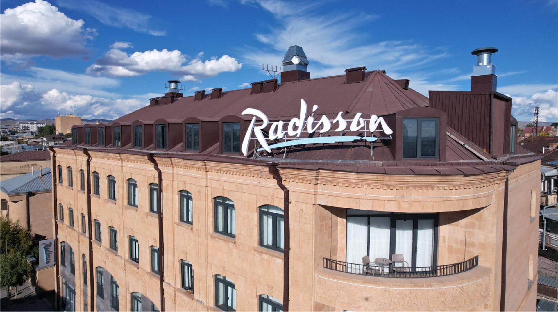 radisson hotel mit dachlogo, mansardenfenstern und balkon