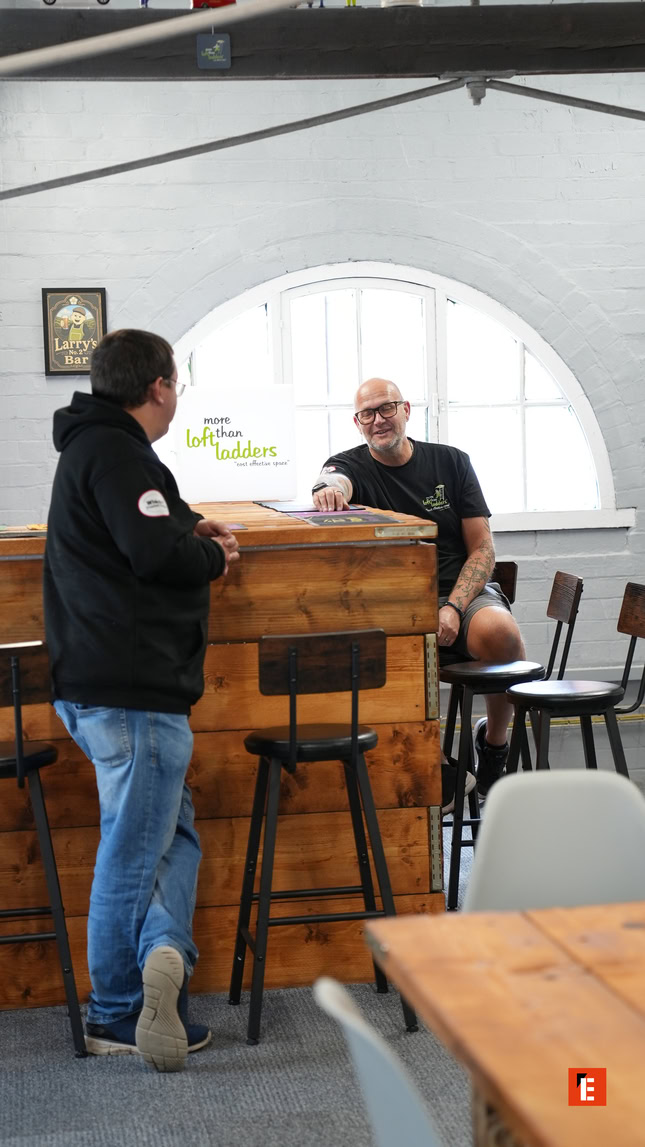 two men chat in a rustic bar interior