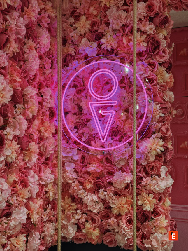 muro di fiori rosa con neon magenta e corde