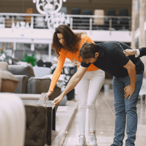 pareja prueba sofá con asesora en showroom