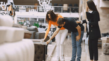 pareja prueba sofá con asesora en showroom