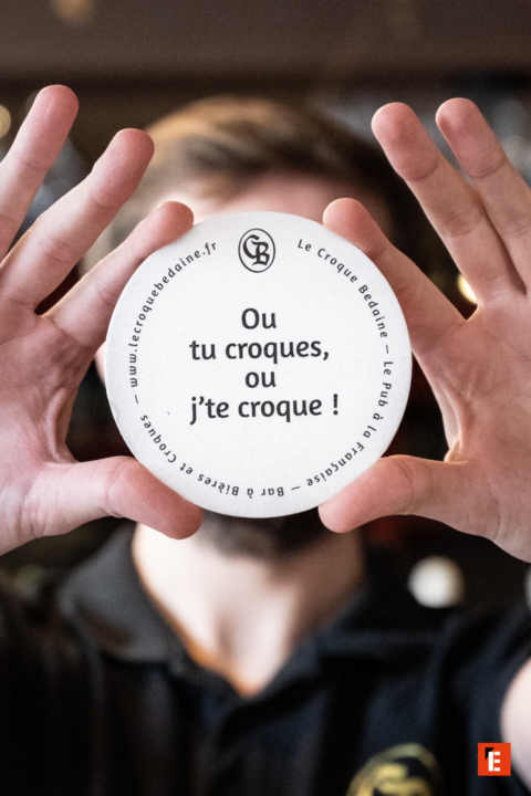 sous bock le croque bedaine tenue par des mains