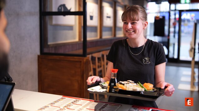 camarera sonriente ofrece sushi para llevar