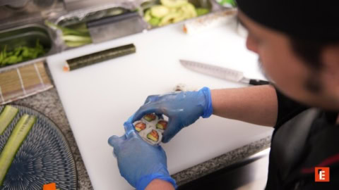 preparación de rollos de sushi con guantes azules