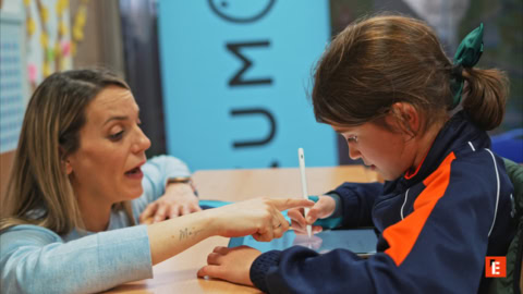 teacher guides child with tablet stylus