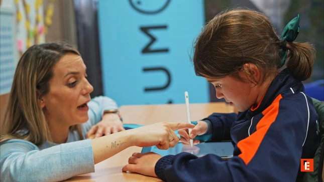 teacher guides child with tablet stylus