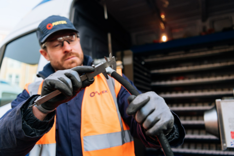 service technician measuring hose with caliper