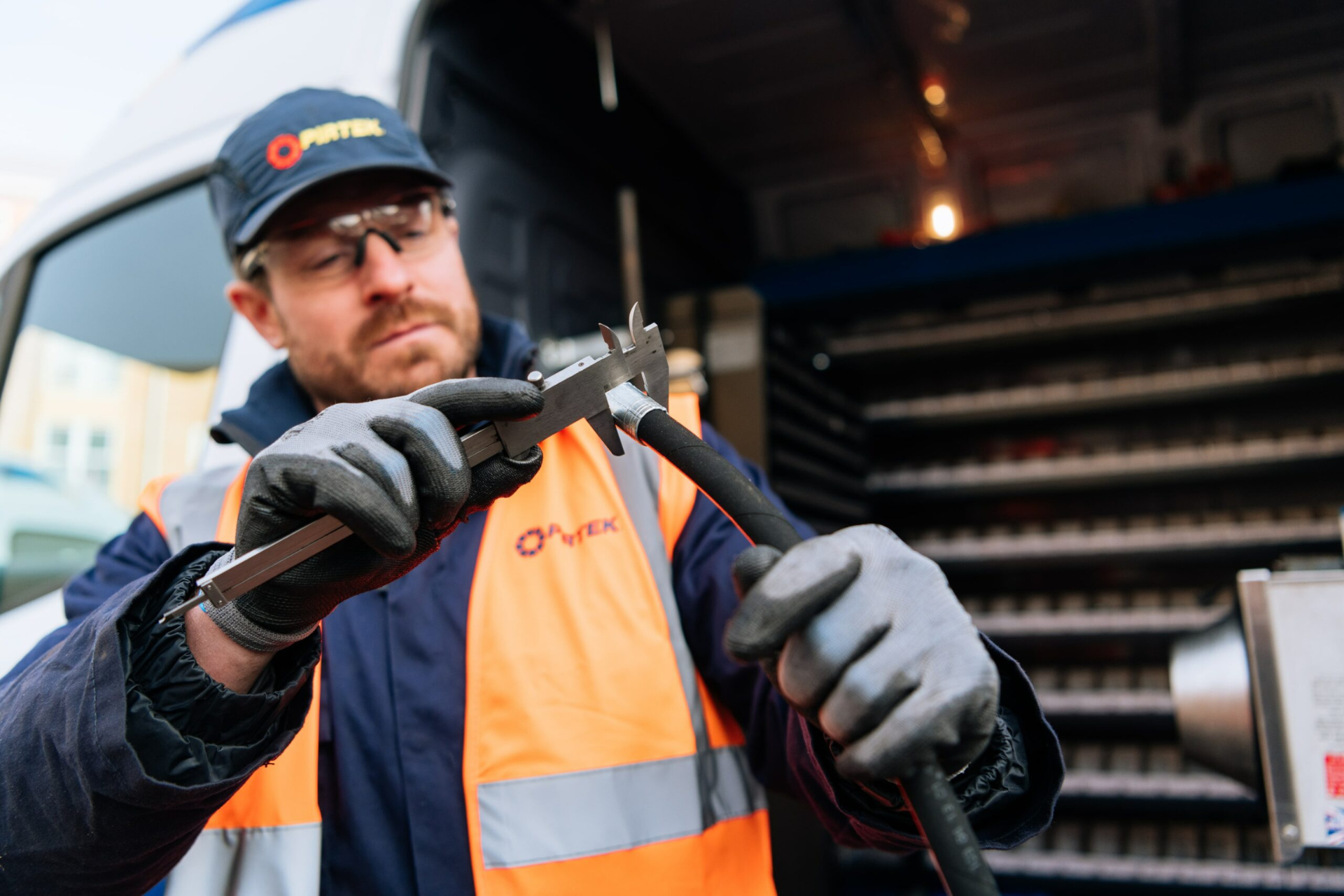 service technician measuring hose with caliper