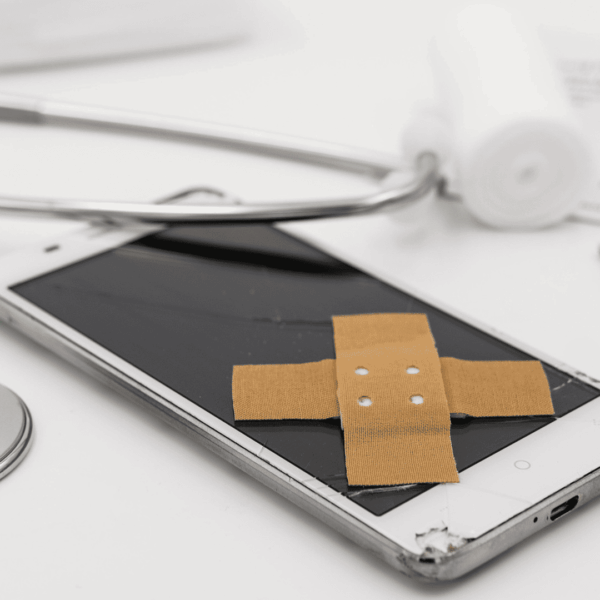 teléfono roto vendado entre instrumentos médicos