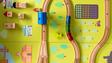 trenino in legno con tunnel su tappeto verde