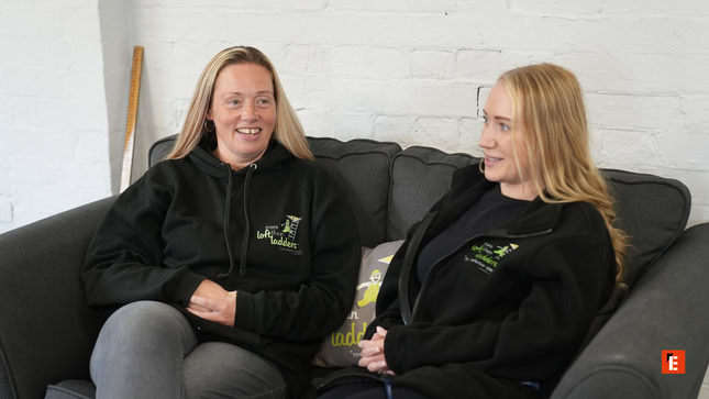 two blonde women chatting on a couch