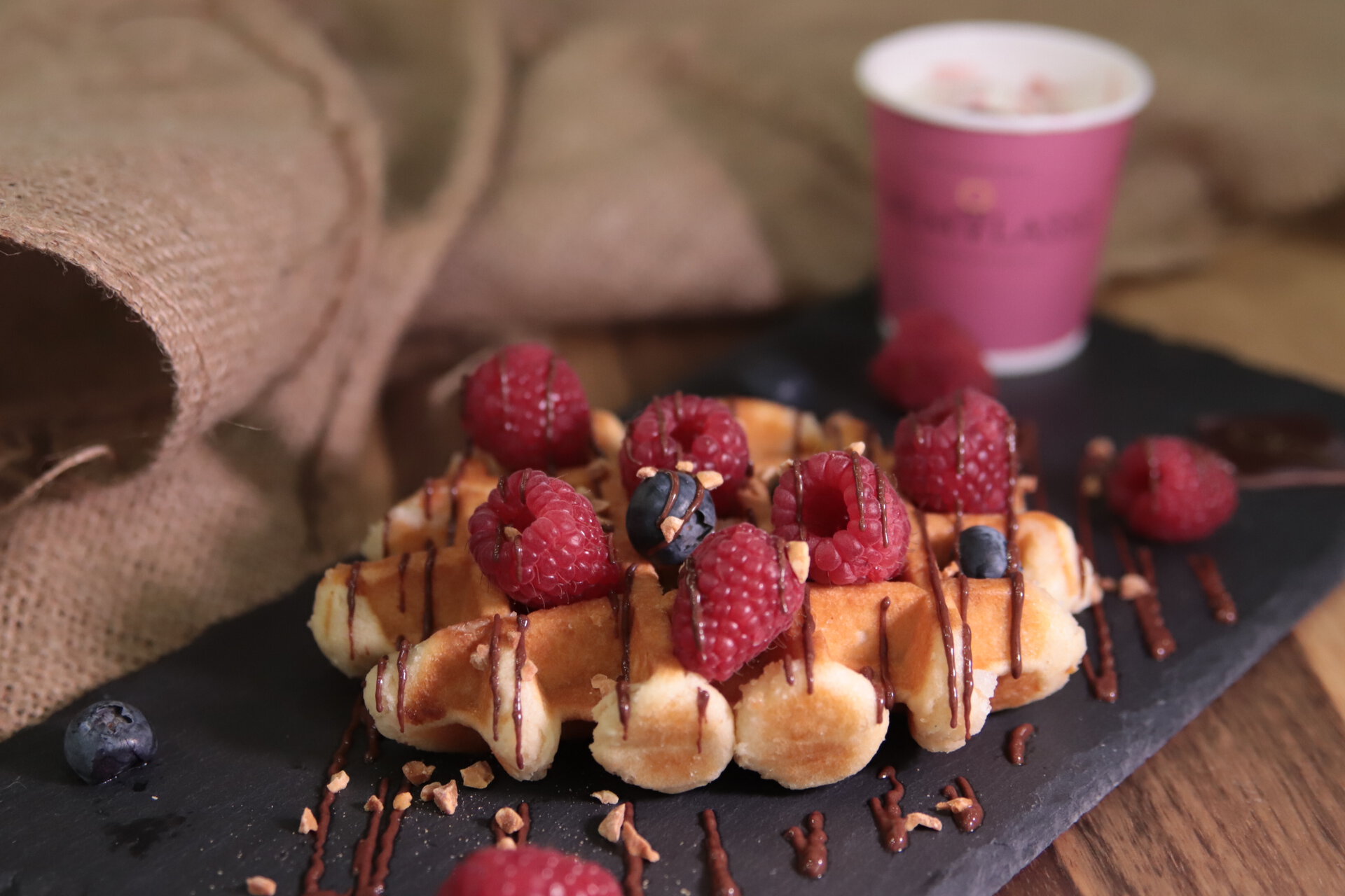 waffle belga al cioccolato con lamponi, mirtilli e nocciole