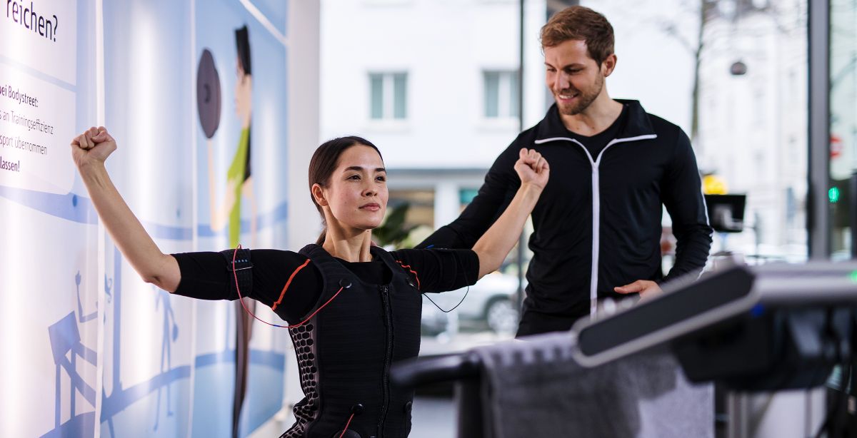 personal trainer supervising wearable electrode workout