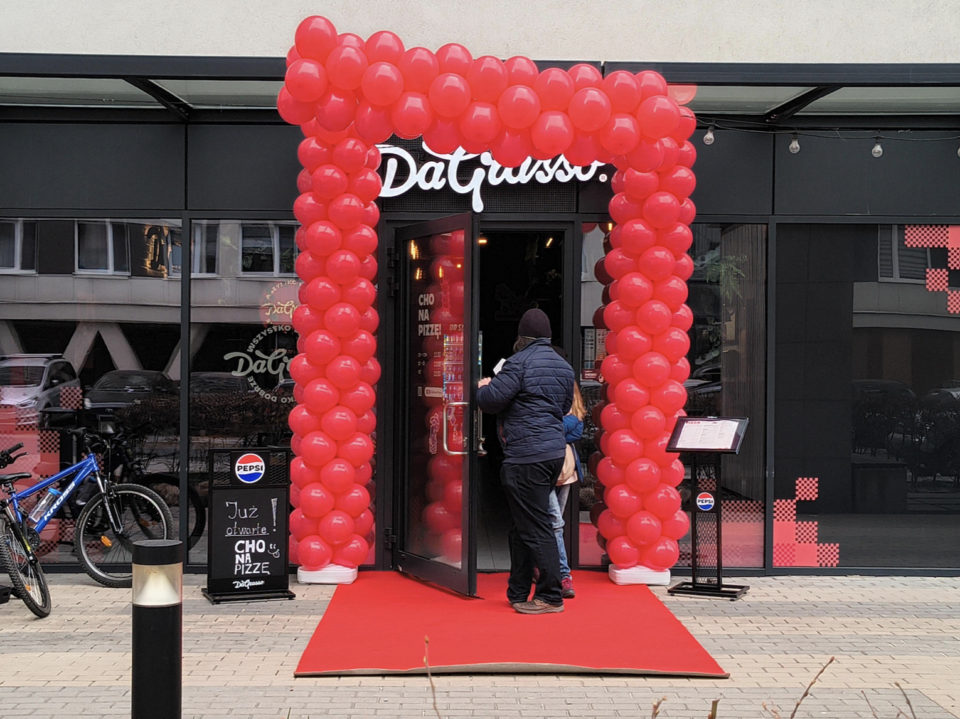 wejście restauracji z czerwonym dywanem i balonami