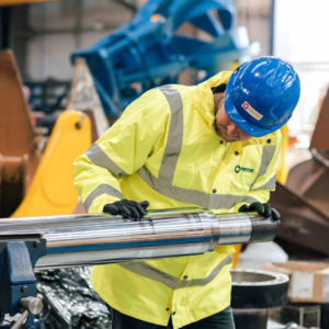technician inspecting polished chrome shaft in workshop