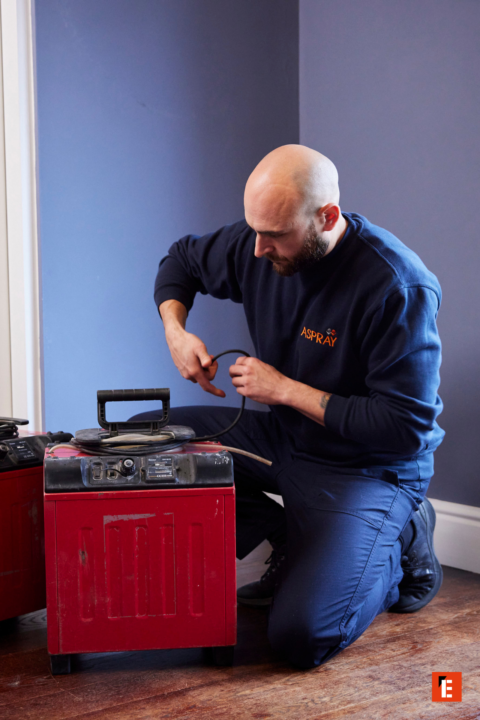 cable technician kneeling by red equipment cases