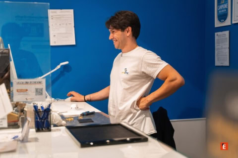 giovane sorridente alla reception in ufficio blu