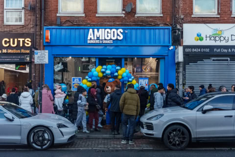 amigos burgers grand opening with mascot and crowd