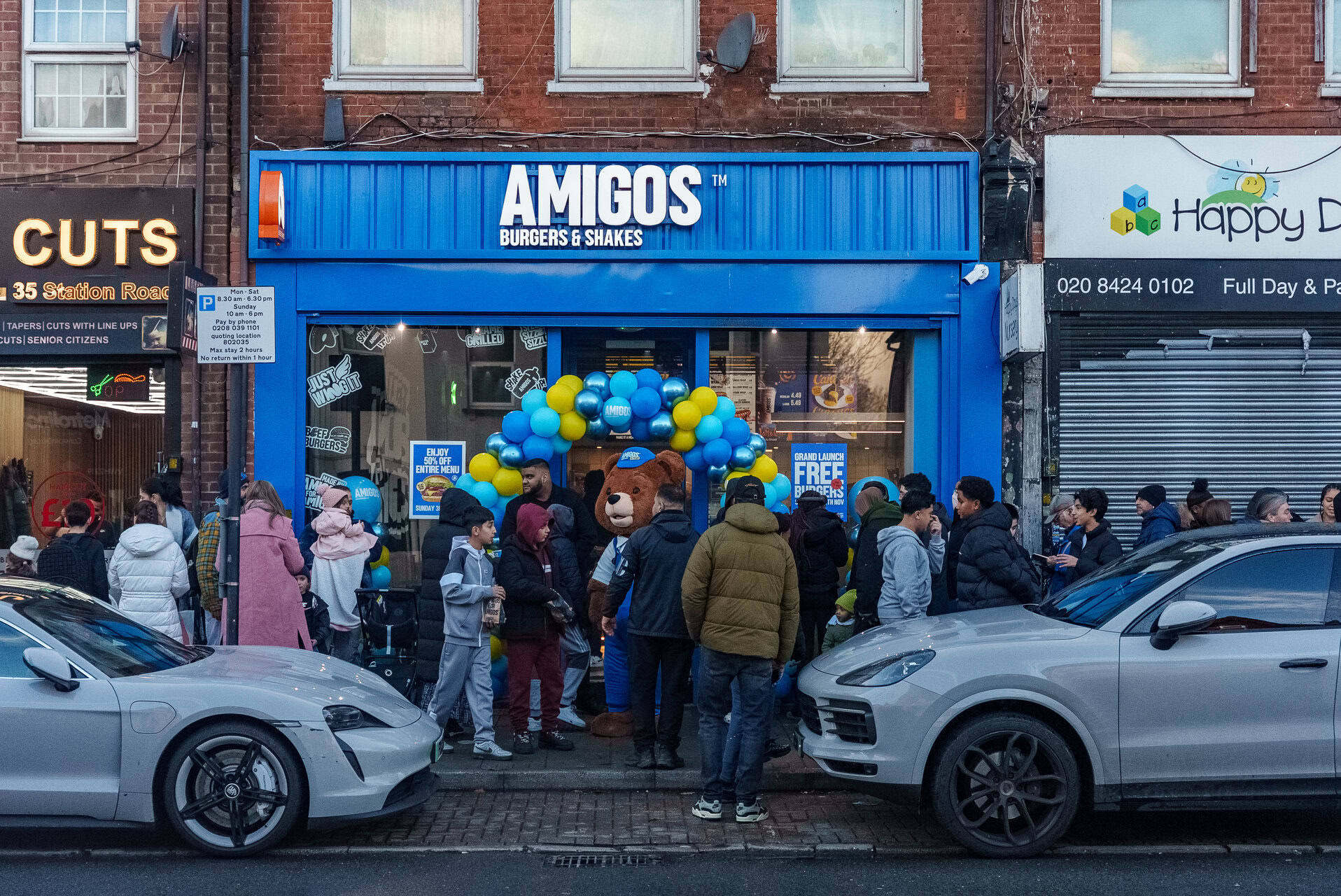 amigos burgers grand opening with mascot and crowd