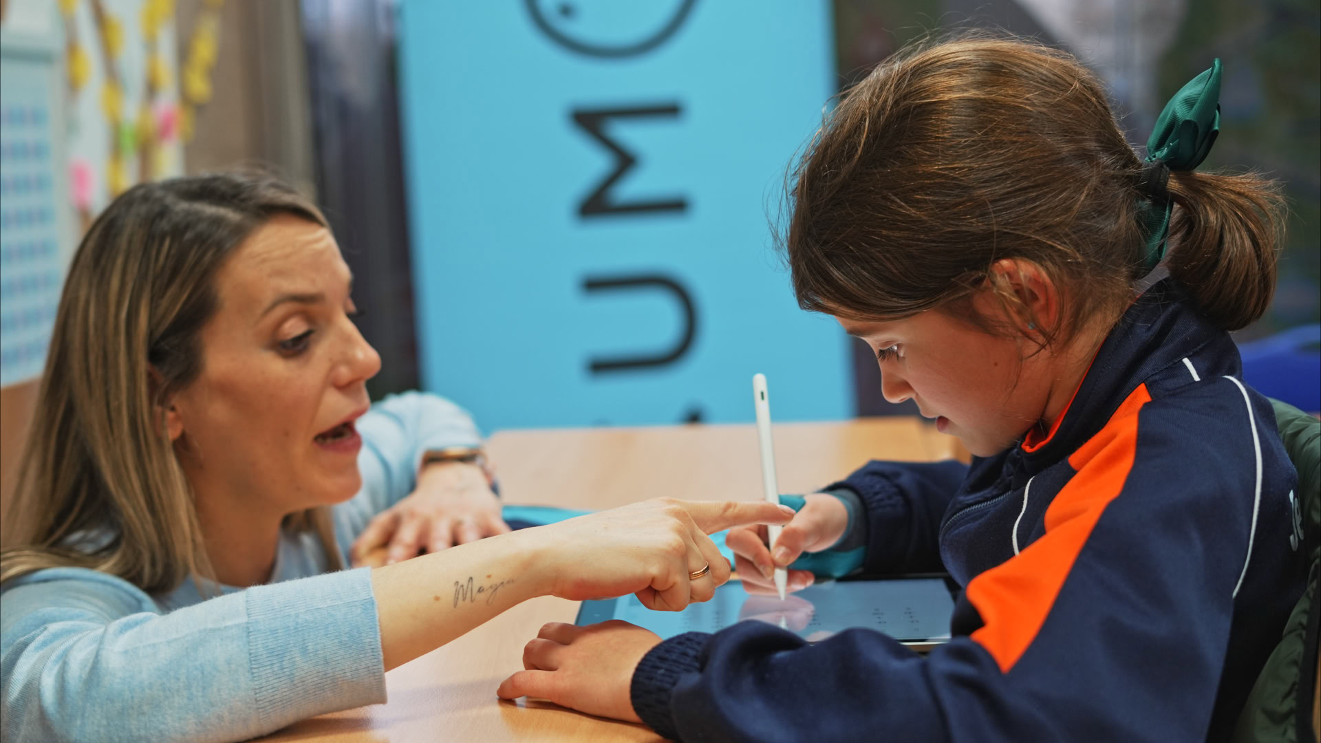 enseignante guidant une Élève sur tablette tactile