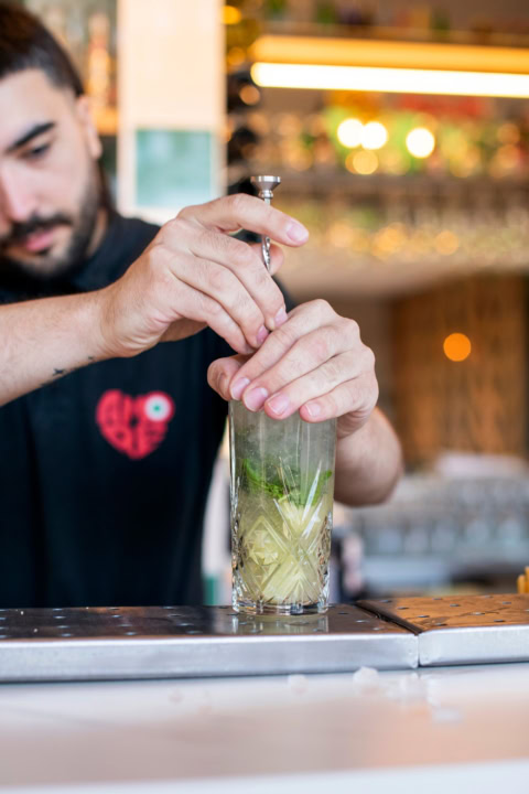 bartender prépare un cocktail artisanal en verre chic
