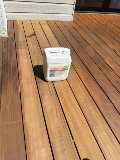 bidon blanc sur terrasse en bois au soleil