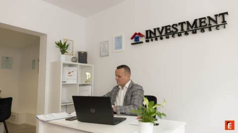 agent inwestycji i nieruchomości przy laptopie
