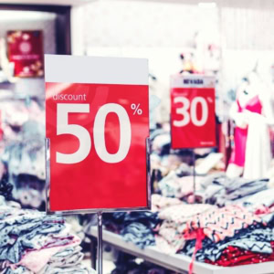 soldes 50% : piles de vêtements en boutique