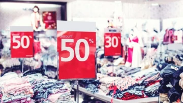 soldes 50% : piles de vêtements en boutique