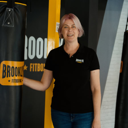 brooklyn fitboxing: palestra con sacchi e istruttore sorridente